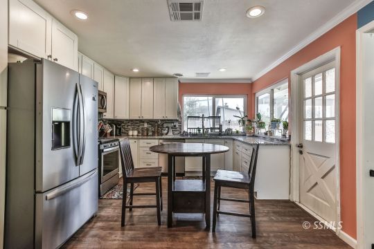 700 Sherri Street Ridgecrest, CA 93555 - Photo 5 of 34 a kitchen with a table chairs refrigerator and microwave