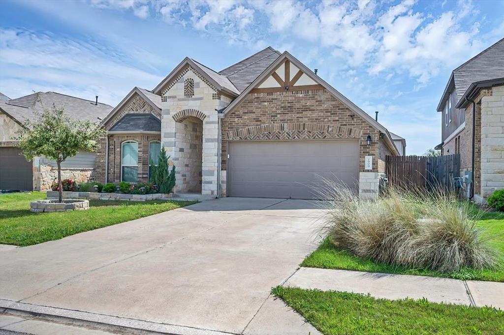 1909 Goldilocks Lane Manchaca, TX 78652 - Photo 2 of 27 a front view of a house with a yard and garage