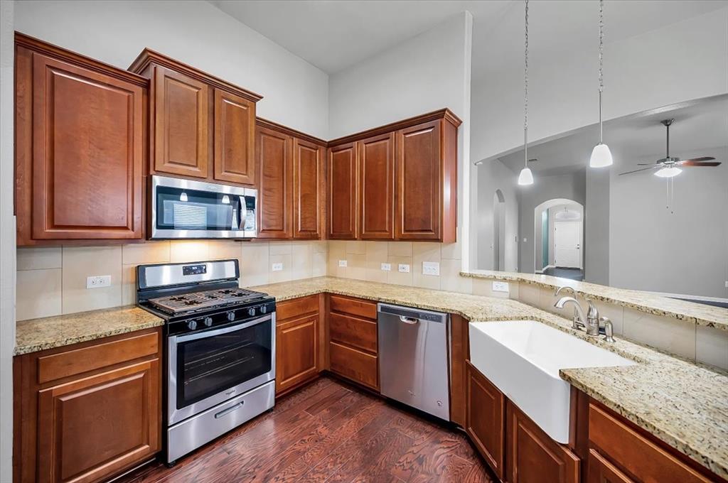 1909 Goldilocks Lane Manchaca, TX 78652 - Photo 7 of 27 a kitchen with stainless steel appliances granite countertop a stove a sink and a microwave