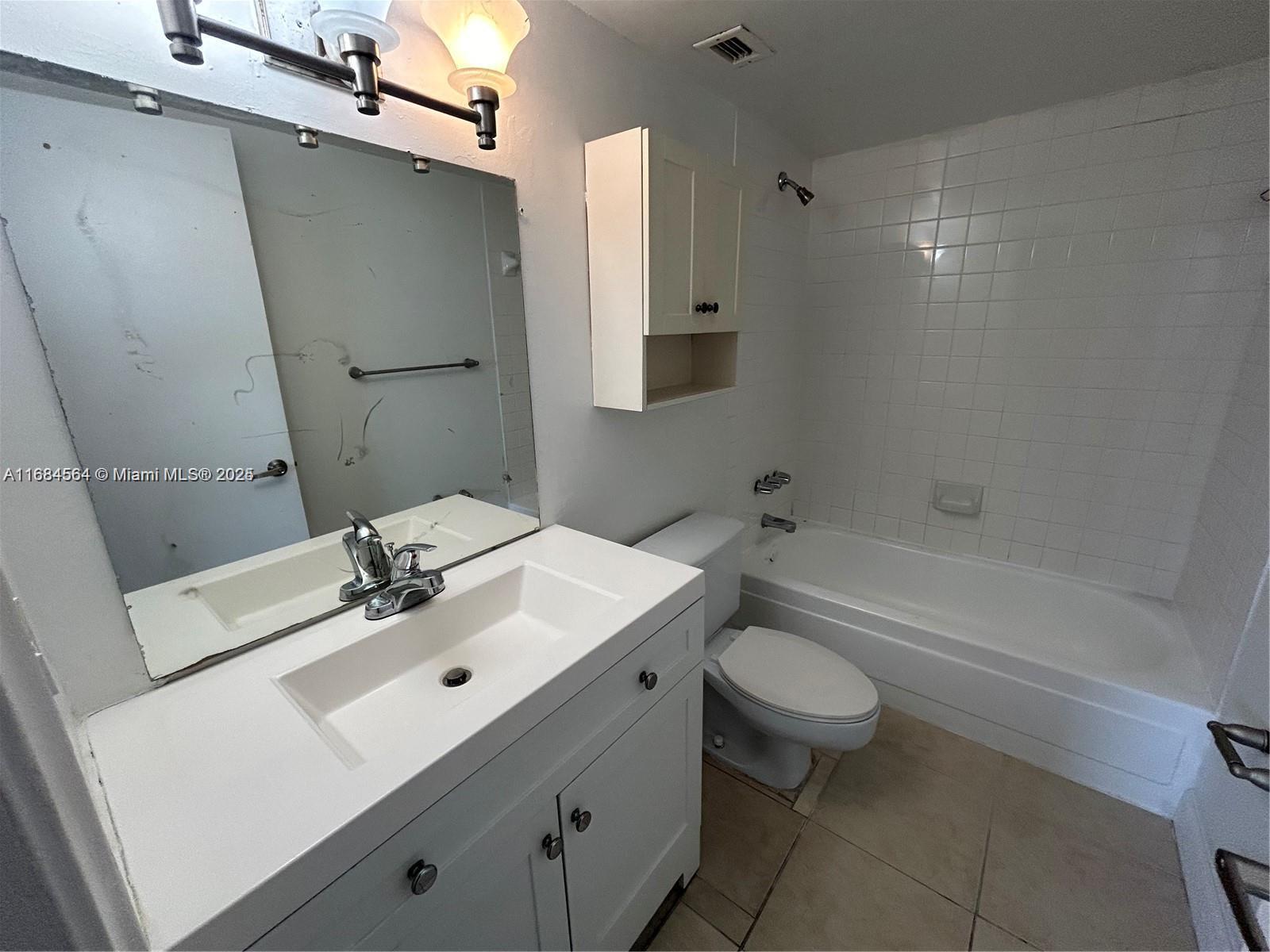9143 Southwest 77th Avenue, Unit B802 Miami, FL 33156 - Photo 5 of 12 a bathroom with a sink a toilet and shower