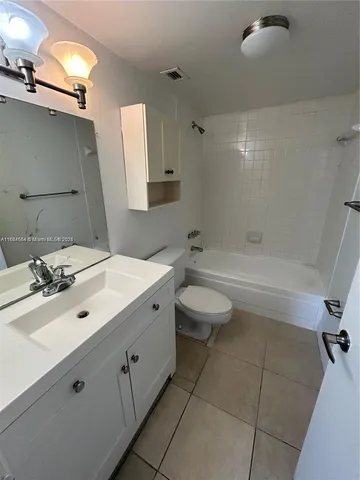 a bathroom with a sink mirror and a bathtub