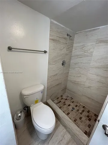 a bathroom with a toilet and a shower