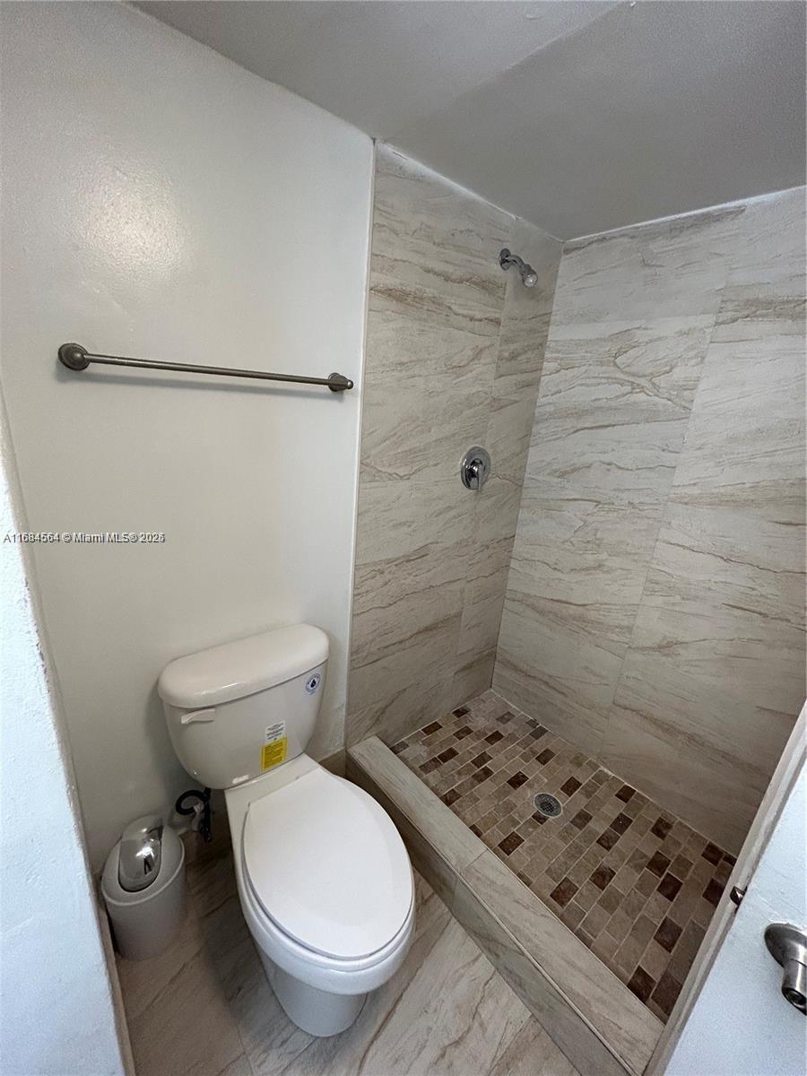 9143 Southwest 77th Avenue, Unit B802 Miami, FL 33156 - Photo 7 of 12 a bathroom with a toilet and a shower