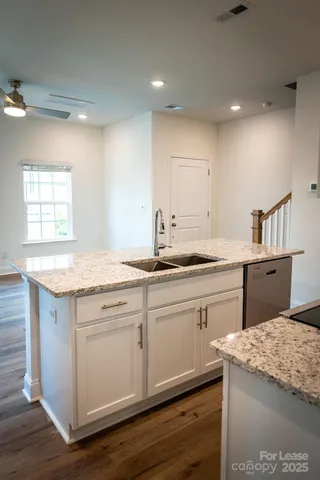 a kitchen with a sink cabinets and wooden floor