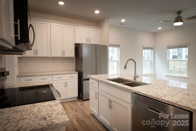 a kitchen with stainless steel appliances granite countertop a sink stove and refrigerator