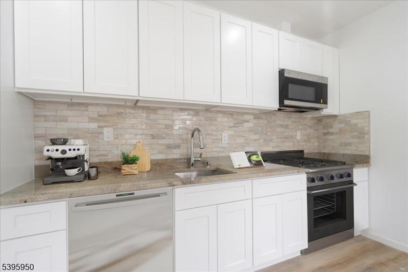 813 South 12th Street Newark, NJ 07108 - Photo 3 of 14 a kitchen with stainless steel appliances granite countertop a sink a stove a microwave and cabinets
