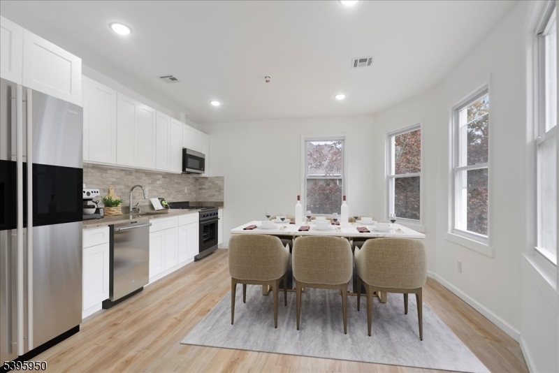 813 South 12th Street Newark, NJ 07108 - Photo 4 of 14 a large dining space with stainless steel appliances granite countertop a stove a sink a dining table and chairs