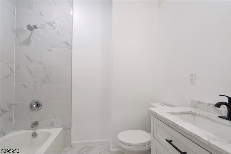 813 South 12th Street Newark, NJ 07108 - Photo 6 of 14 a bathroom with a granite countertop toilet a sink a mirror and bathtub