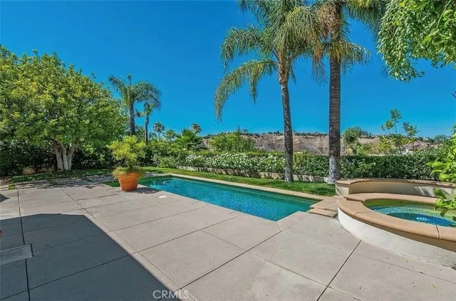 a view of a house with backyard sitting area and swimming pool