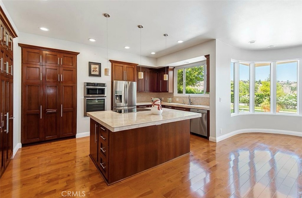 24907 Marbella Court Calabasas, CA 91302 - Photo 8 of 34 a kitchen with kitchen island granite countertop a sink and a refrigerator