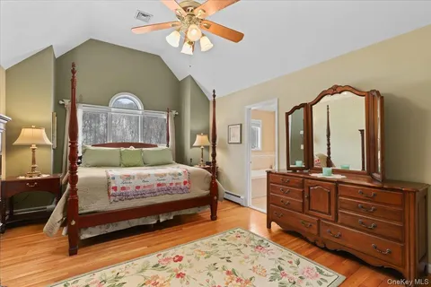 a bedroom with a bed a mirror on dresser and a chandelier