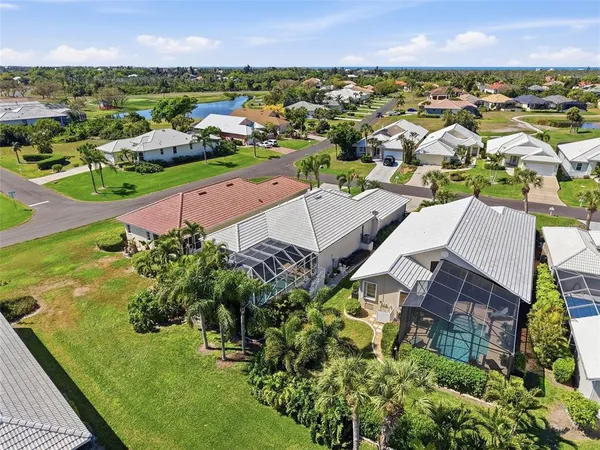 an aerial view of residential houses with outdoor space and trees