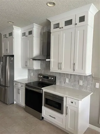 a kitchen with stainless steel appliances granite countertop a stove a refrigerator and a sink