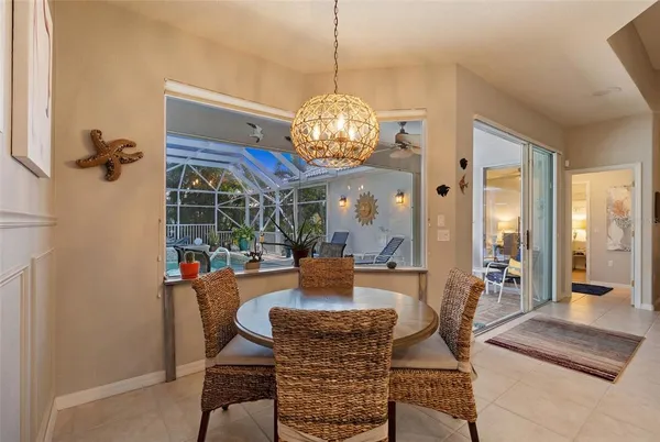 a dining room with furniture a chandelier and wooden floor