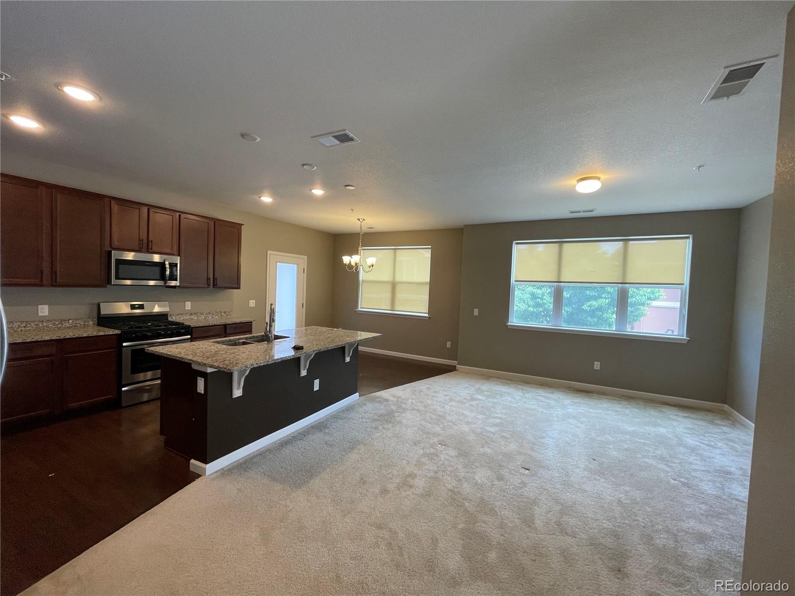 4604 Copeland Circle, Unit 103 Highlands Ranch, CO 80126 - Photo 2 of 11 a kitchen with stainless steel appliances granite countertop a stove a sink a refrigerator and a granite counter tops