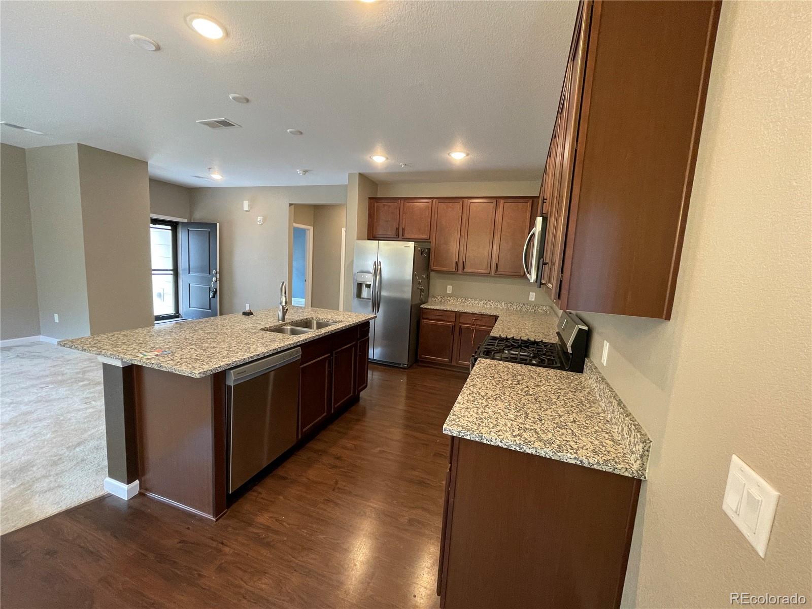 4604 Copeland Circle, Unit 103 Highlands Ranch, CO 80126 - Photo 4 of 11 a kitchen with a stove and a refrigerator