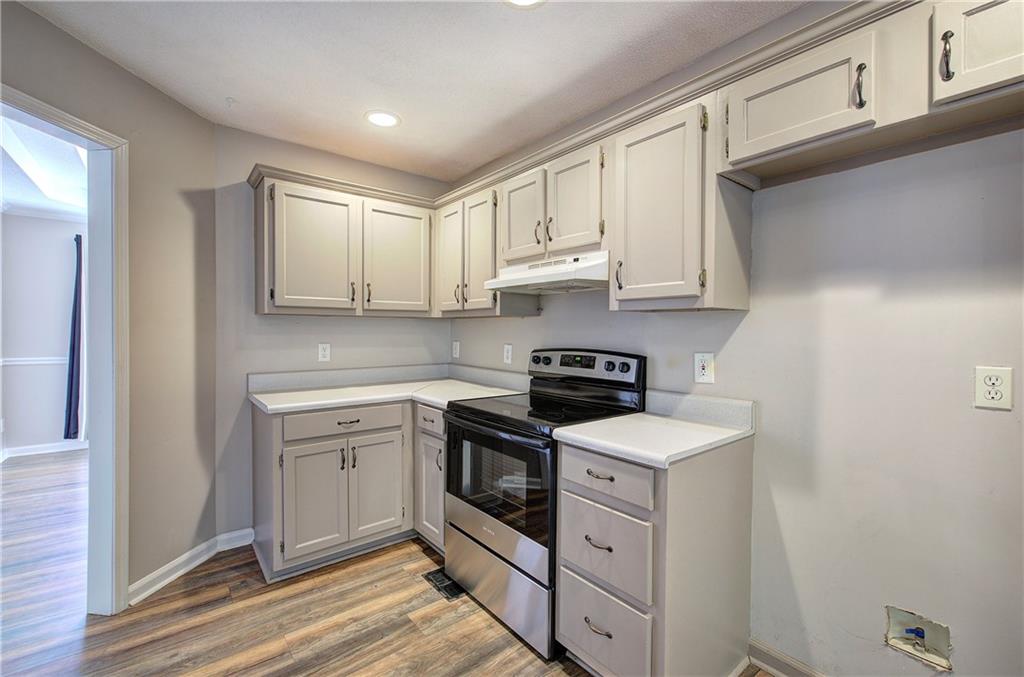 15 Roving Hills Circle Cartersville, GA 30121 - Photo 17 of 55 a kitchen with stainless steel appliances granite countertop a sink and dishwasher a stove top oven with white cabinets