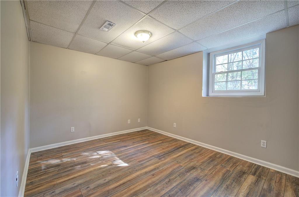 15 Roving Hills Circle Cartersville, GA 30121 - Photo 38 of 55 en empty room with wooden floor and windows