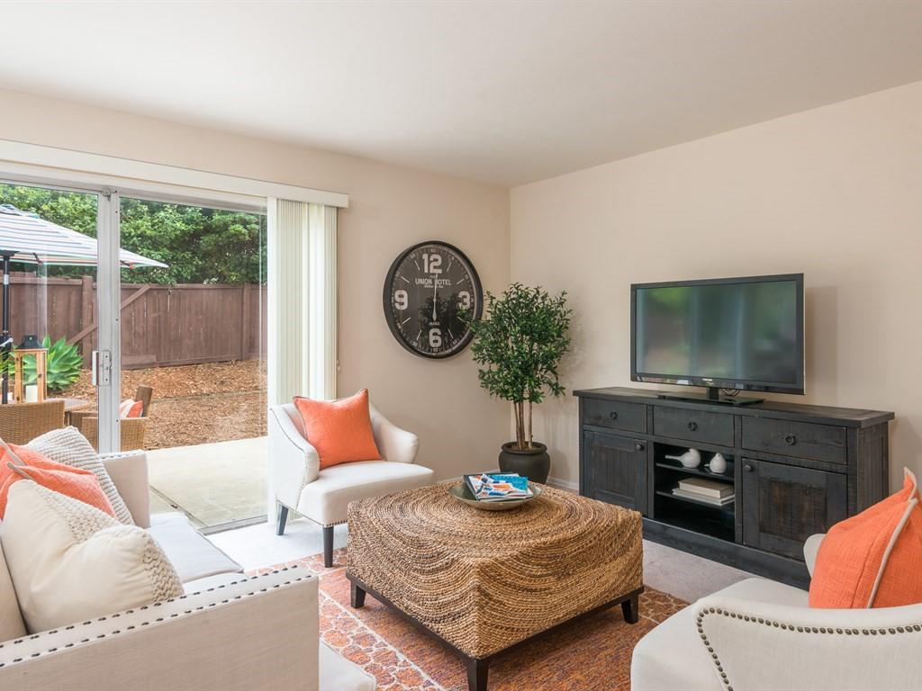 a living room with furniture a large window and a flat screen tv