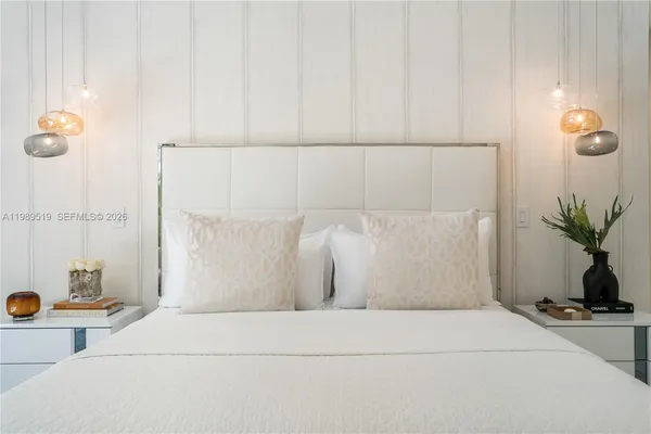 a bedroom with a bed and large windows