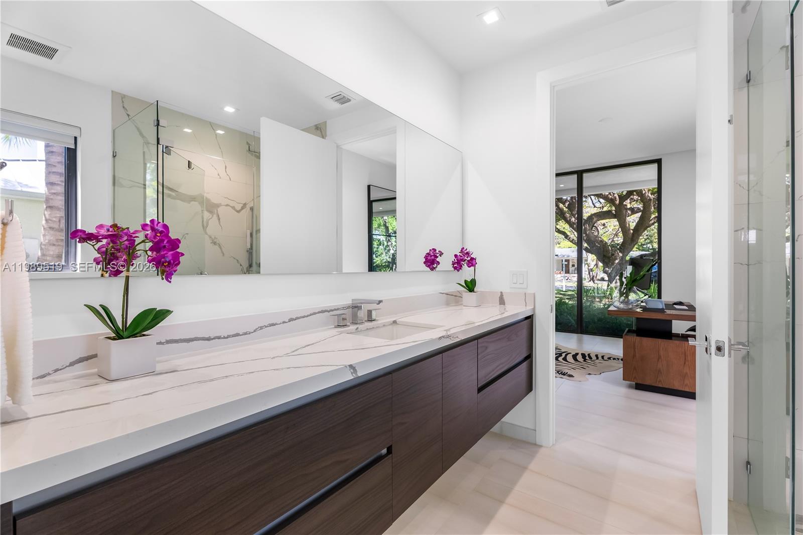 7900 Southwest 57th Court South Miami, FL 33143 - Photo 30 of 55 a bathroom with a granite countertop sink a mirror and a bathtub
