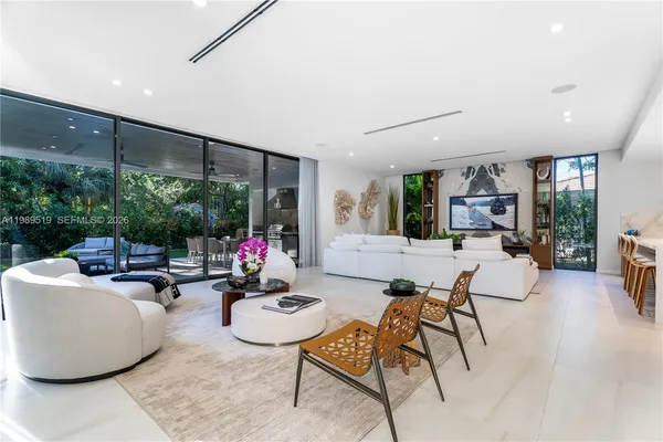 a living room with furniture and potted plants