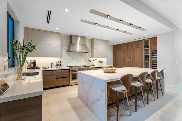 a kitchen with kitchen island a dining table and chairs