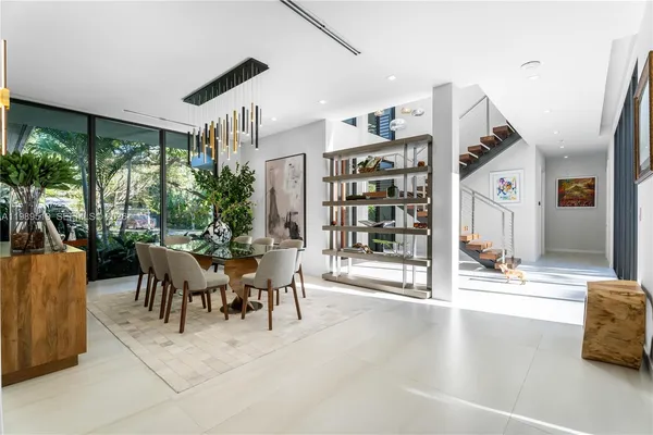 a view of a dining room with furniture and floor to ceiling window