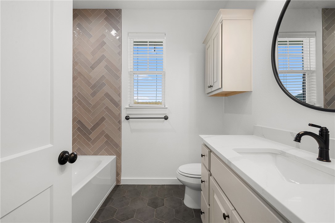 5020 Toscana Loop Bryan, TX 77802 - Photo 17 of 32 a bathroom with a sink a toilet and a mirror