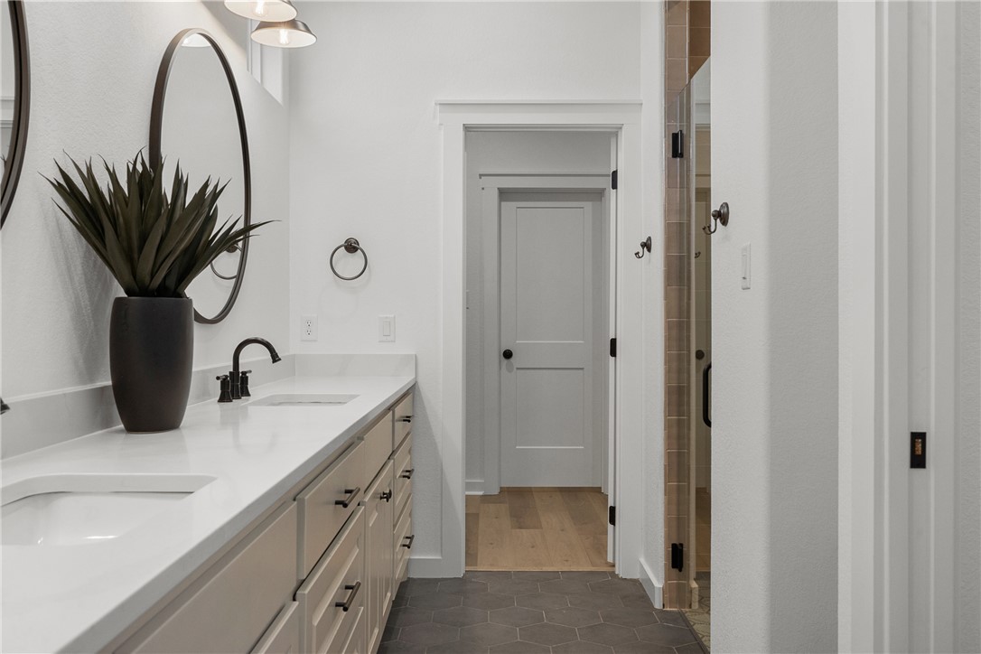 5020 Toscana Loop Bryan, TX 77802 - Photo 22 of 32 a bathroom with a granite countertop sink a mirror and a shower