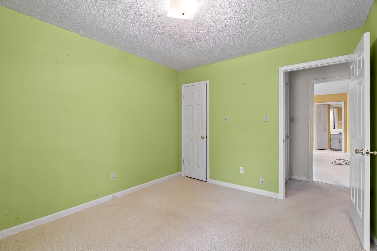7008 Crestridge Road Memphis, TN 38119 - Photo 18 of 25 Unfurnished bedroom with baseboards, light carpet, and a textured ceiling