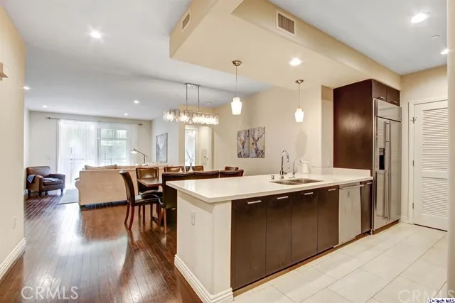 a kitchen with stainless steel appliances granite countertop a sink a stove and a refrigerator