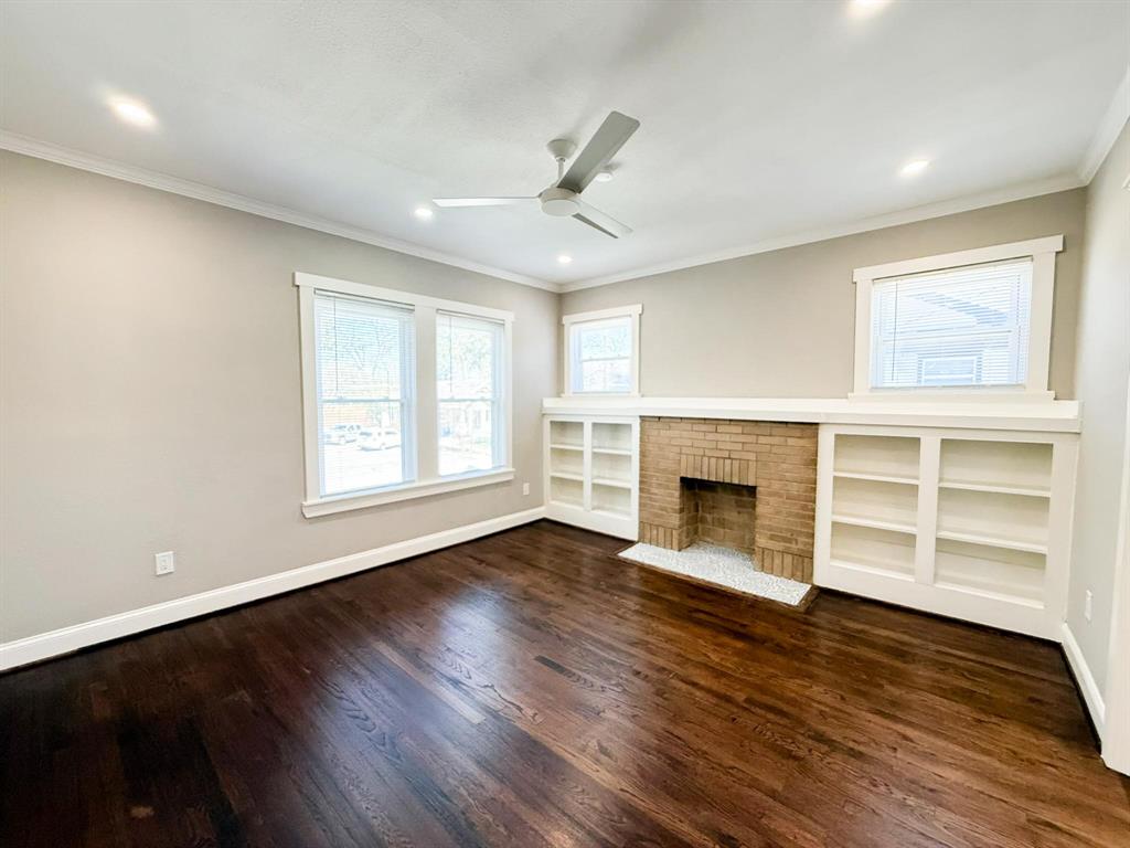 4114 Junius Street, Unit B Dallas, TX 75246 - Photo 6 of 23 an empty room with wooden floor fireplace and windows