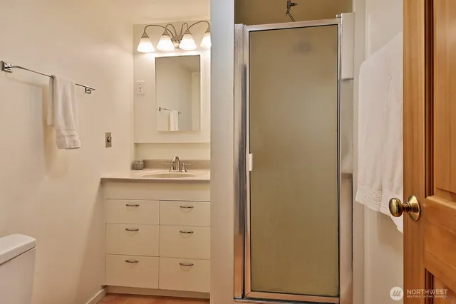 a bathroom with a granite countertop sink a mirror and a shower