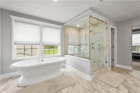 a spacious bathroom with a tub shower and windows