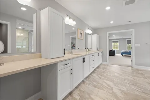 a large white bathroom with a large mirror vanity and shower