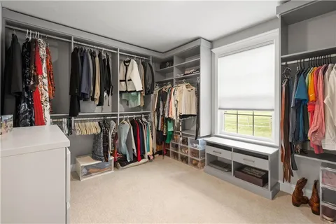 a view of walk in closet with clothes and shoes