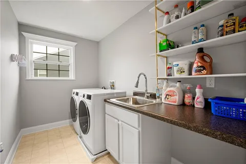 a utility room with sink dryer and washer