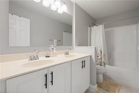 a bathroom with a granite countertop sink a toilet and a bathtub