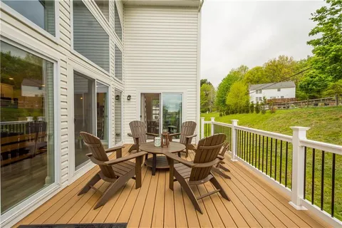 a view of a roof deck with table and chairs and wooden floor