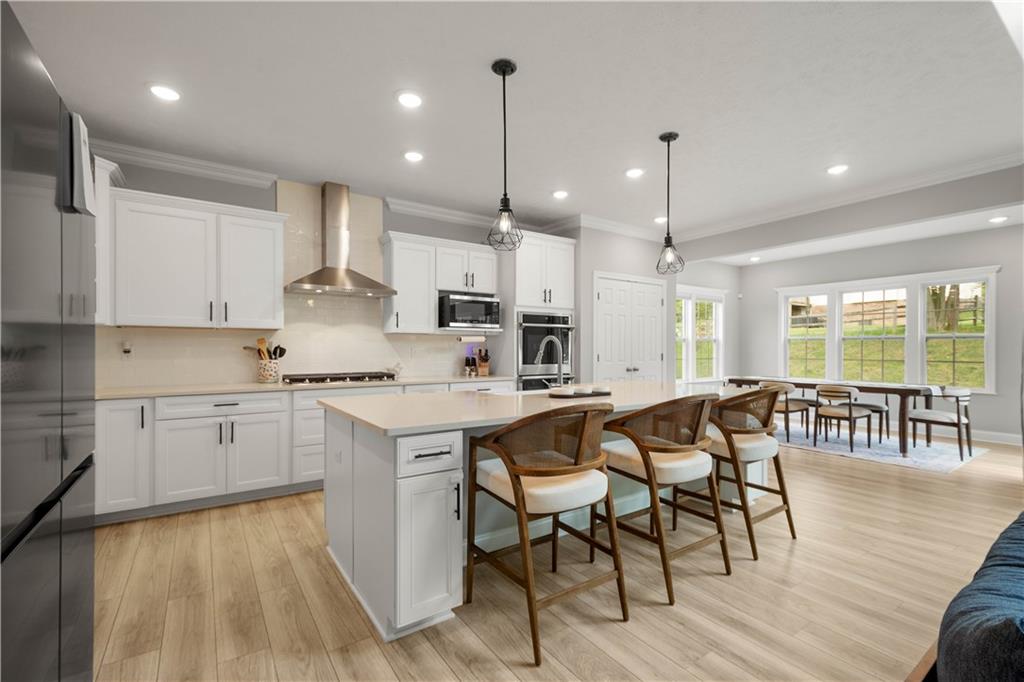 1197 Brook View Court Pittsburgh, PA 15237 - Photo 8 of 30 a kitchen with kitchen island granite countertop lots of white cabinets stainless steel appliances dining table and chairs