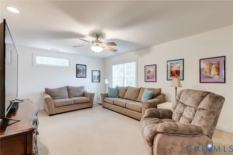 a living room with furniture and a ceiling fan