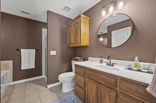a bathroom with a toilet sink vanity and mirror