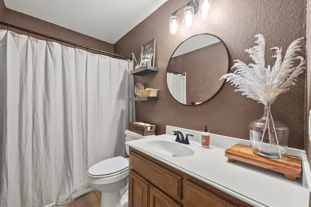 a bathroom with a sink vanity mirror and toilet