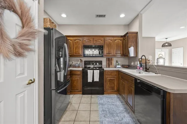 a kitchen with stainless steel appliances granite countertop a refrigerator and a sink