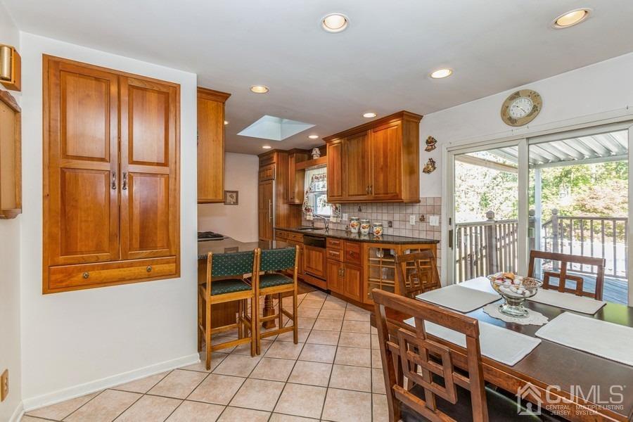 12 New Street Middlesex, NJ 08846 - Photo 5 of 20 a kitchen with stainless steel appliances granite countertop a stove a refrigerator a sink a dining table and chairs with wooden floor