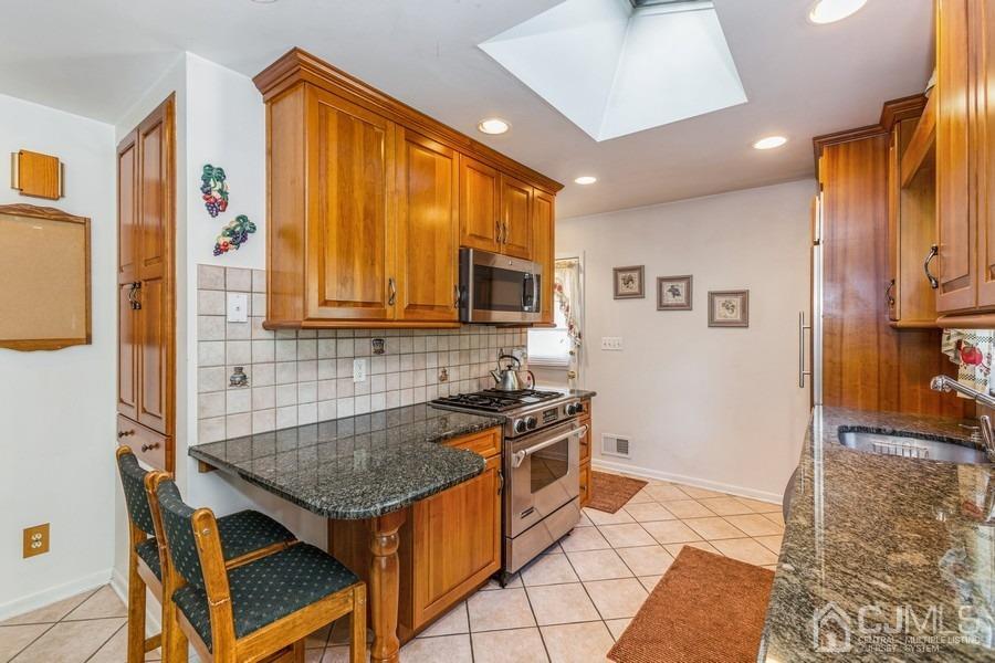 12 New Street Middlesex, NJ 08846 - Photo 6 of 20 a kitchen with stainless steel appliances granite countertop a stove a sink dishwasher and a refrigerator