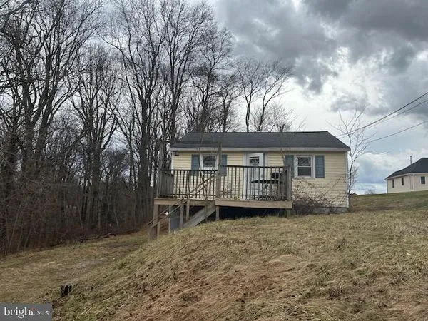 a view of a house with a yard and large trees