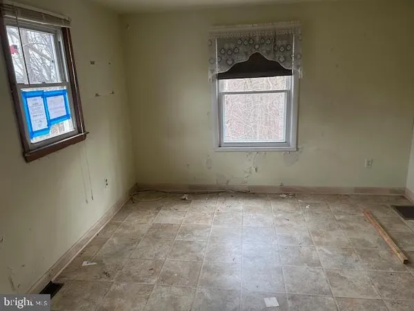 an empty room with windows and cabinet