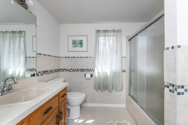 a bathroom with a granite countertop sink toilet and shower